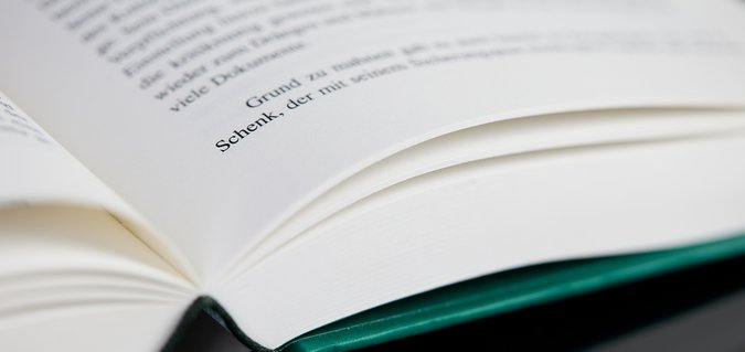 Aufgeschlagenes Hardcover-Buch in Nahaufnahme Aufgeschlagenes Hardcover-Buch in Nahaufnahme